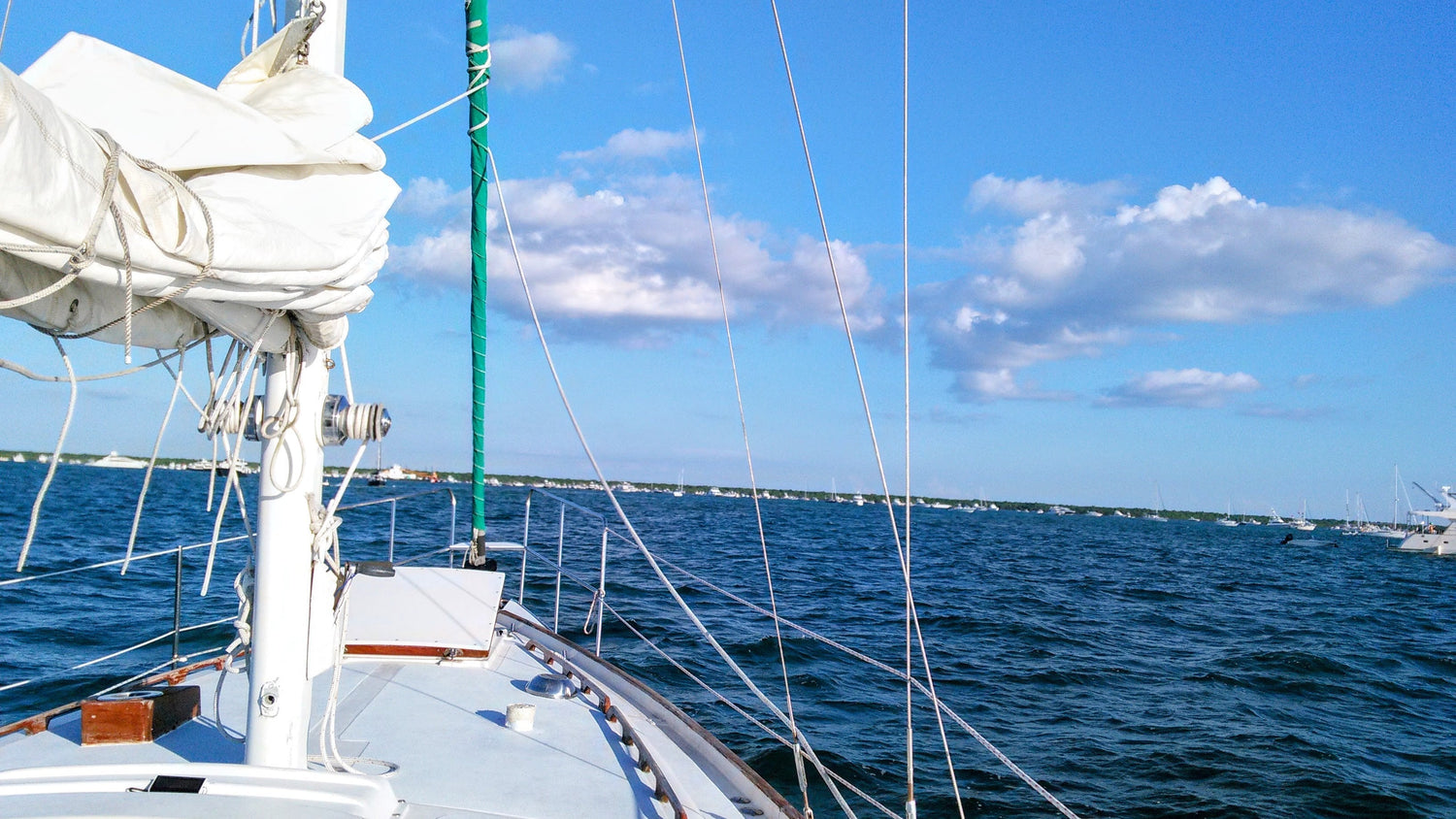 "View from the deck of Southern Star, the Sailing Religion vessel, under clear skies and calm seas—sails furled, lines tight, and freedom ahead."