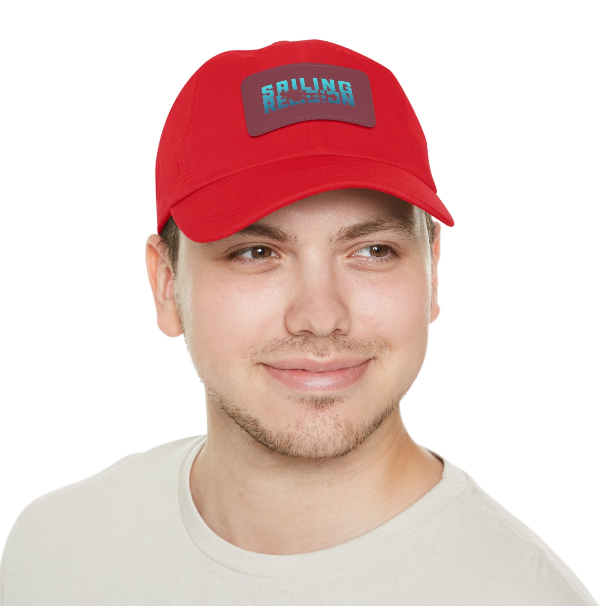 Man wearing a red Sailing Religion hat featuring a bold embroidered patch logo in teal and navy — nautical lifestyle cap designed for everyday wear, sailing, and coastal adventures.